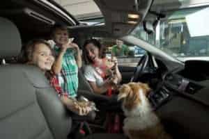 alt="family in car going through bank drive thru"