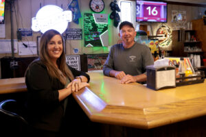 Lender Alexis sits at bar with her customer, Jon